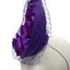 Cadbury purple coloured percher hat with purple roses in the centre and finished with a purple netting over the headpiece.